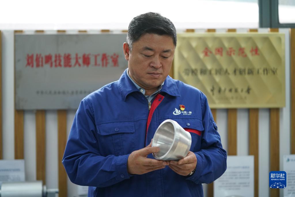 刘伯鸣在工作室内查看创新产品模型（2022年9月17日摄）。